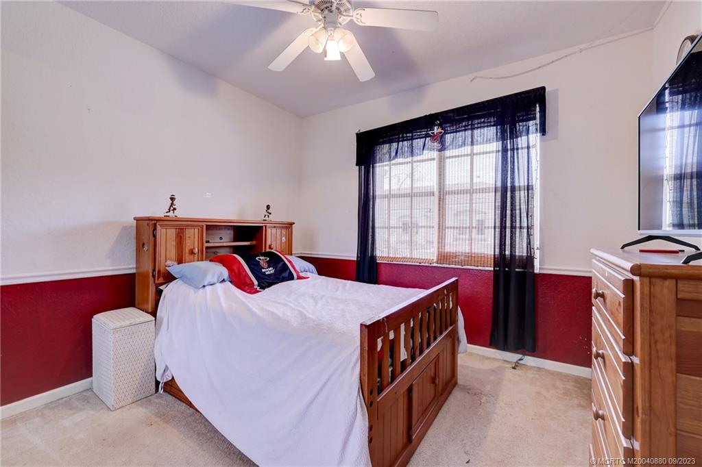 316 Southwest Otter Run Place Stuart, FL 34997 - Photo 29 of 50 a bedroom with a bed and a chandelier