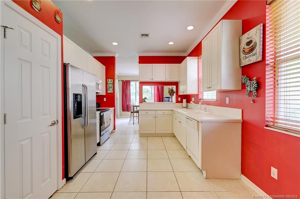 316 Southwest Otter Run Place Stuart, FL 34997 - Photo 7 of 50 a kitchen with stainless steel appliances kitchen island granite countertop a sink and cabinets