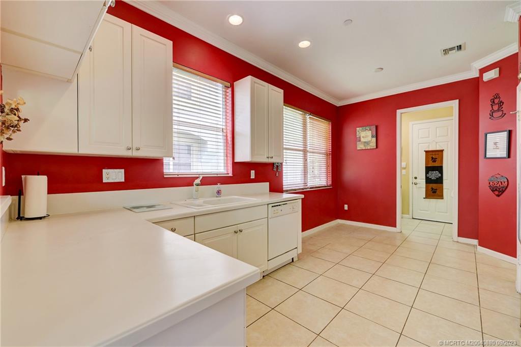 316 Southwest Otter Run Place Stuart, FL 34997 - Photo 9 of 50 a kitchen with granite countertop a stove a sink and a microwave