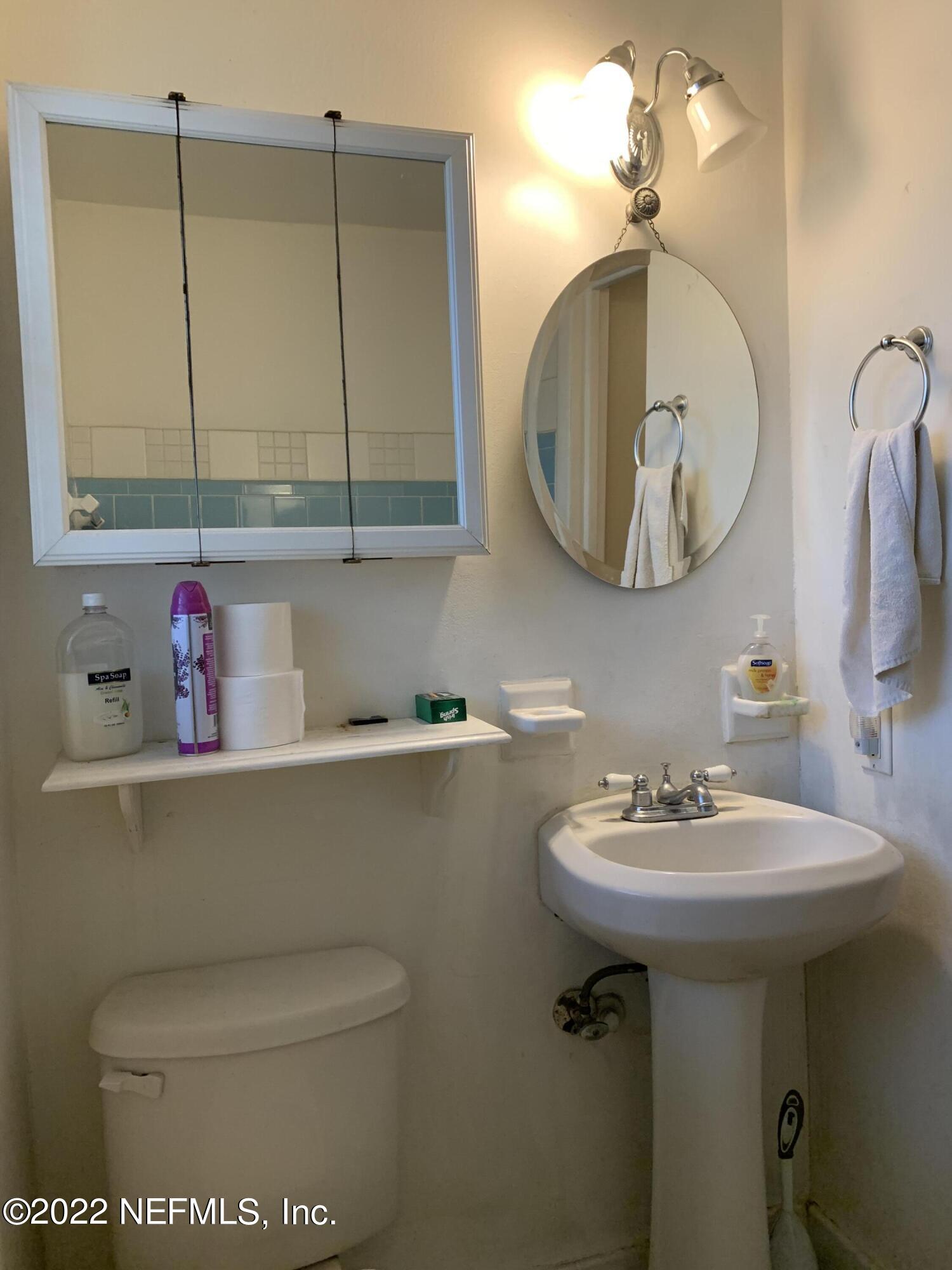 7014 Rollo Road Jacksonville, FL 32205 - Photo 4 of 21 a bathroom with a toilet sink and mirror