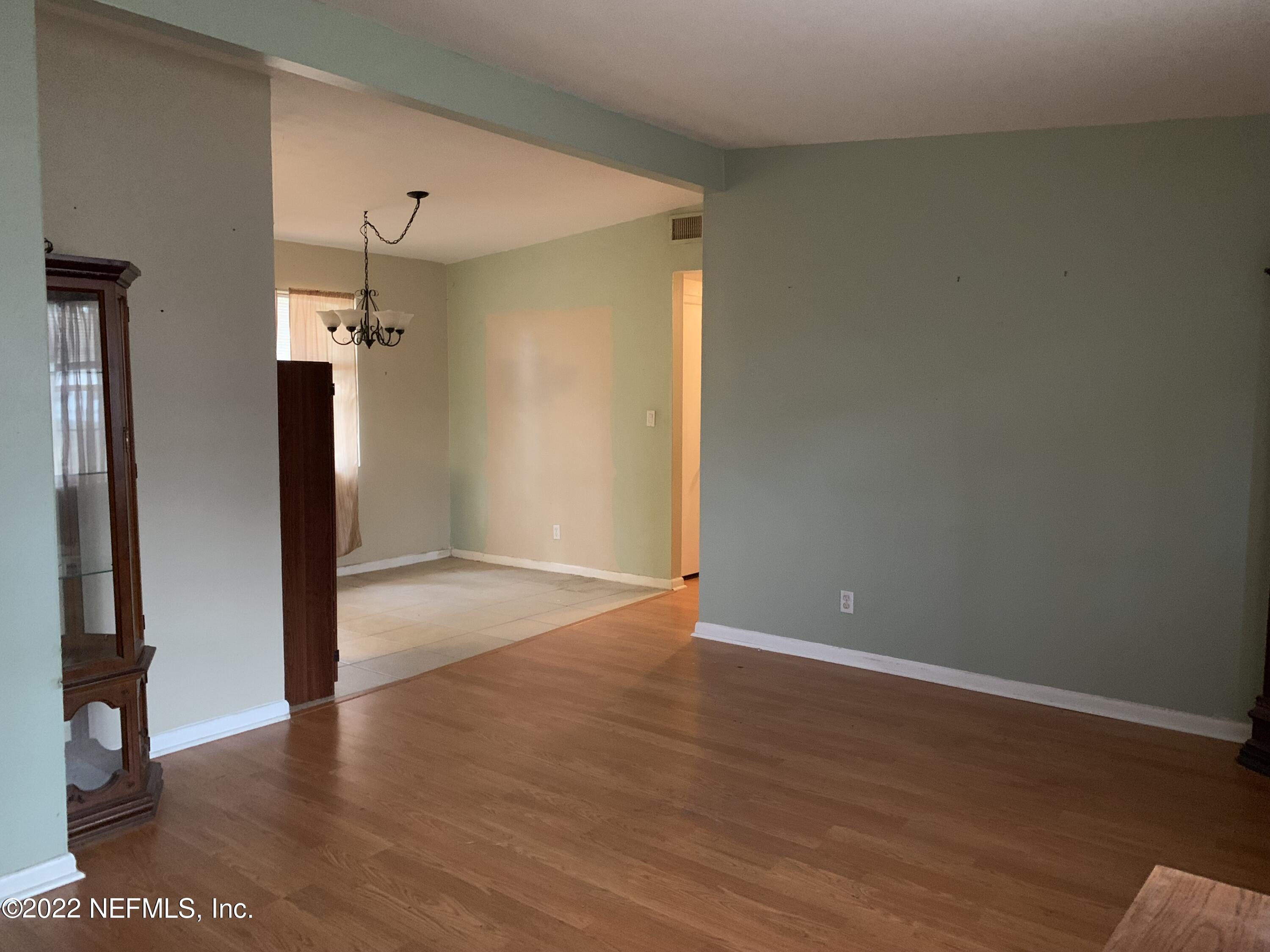 7014 Rollo Road Jacksonville, FL 32205 - Photo 5 of 21 an empty room with wooden floor and a large window