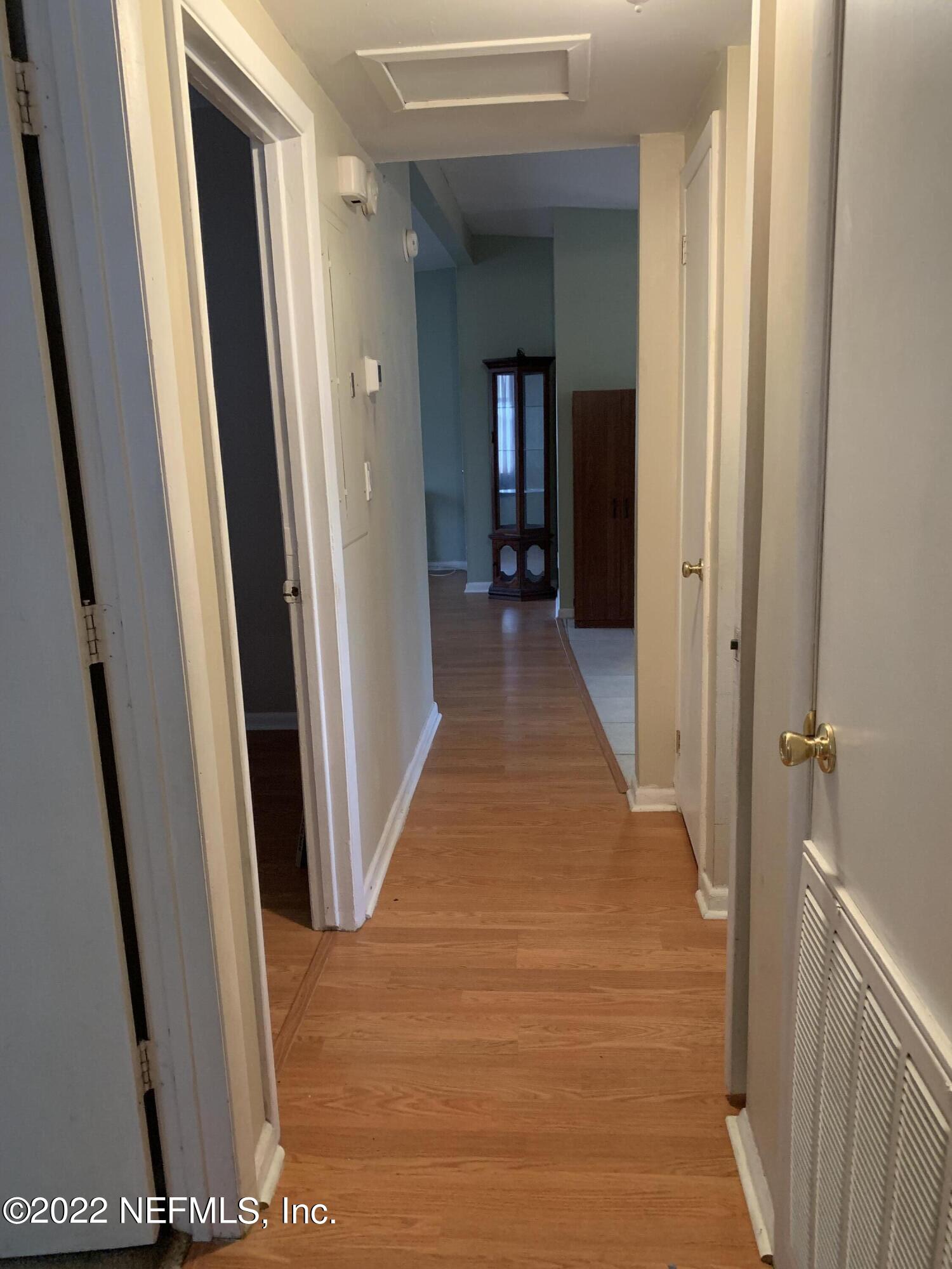 7014 Rollo Road Jacksonville, FL 32205 - Photo 10 of 21 a hallway with wooden floor and stairs