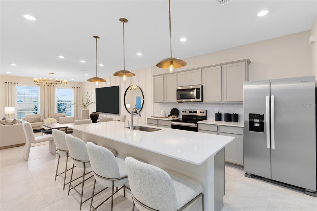 11483 Harborview Street Orlando, FL 32832 - Photo 14 of 26 a kitchen with a refrigerator a stove a sink and chairs