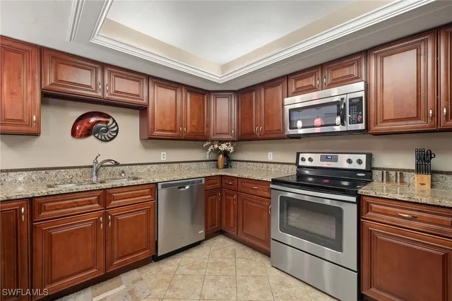 a kitchen with granite countertop cabinets stainless steel appliances and a sink