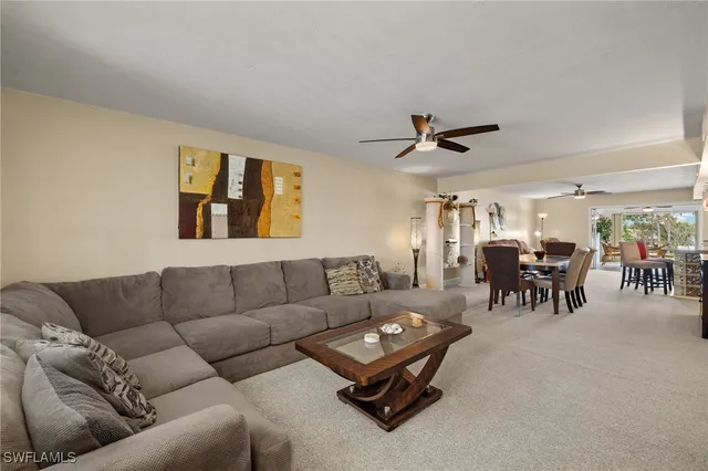 a living room with furniture and a ceiling fan
