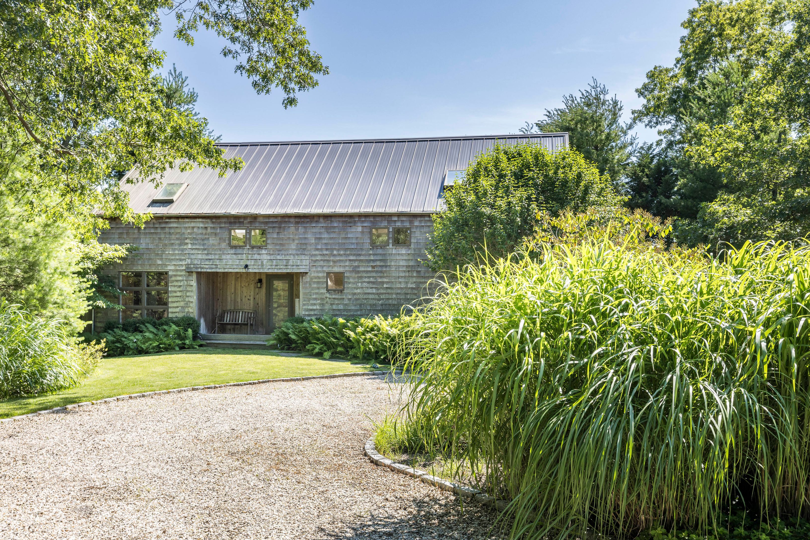 97 Swamp Road East Hampton, NY 11937 - Photo 1 of 28 a front view of a house with a yard and garage