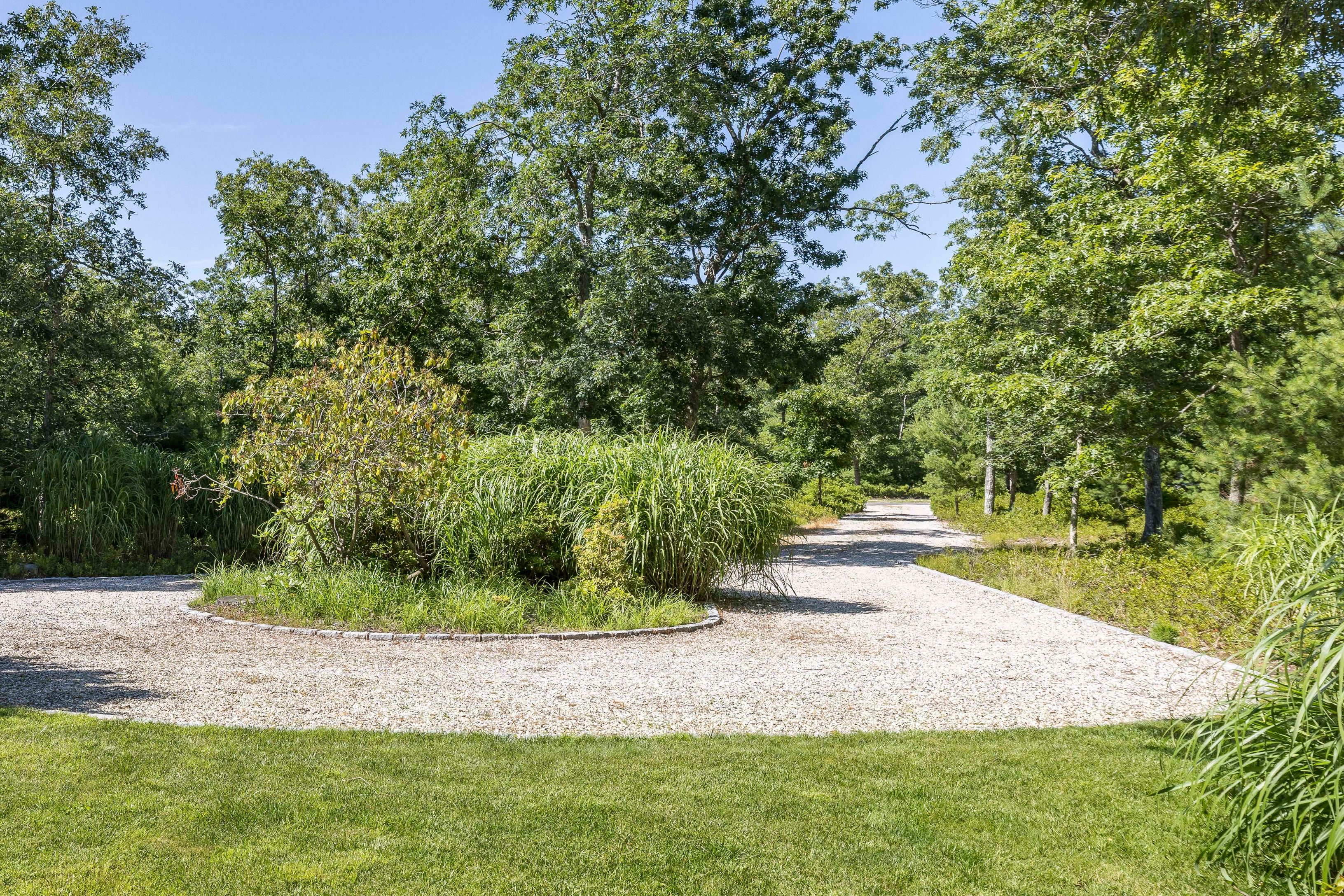 97 Swamp Road East Hampton, NY 11937 - Photo 25 of 28 a view of a yard with plants and large trees