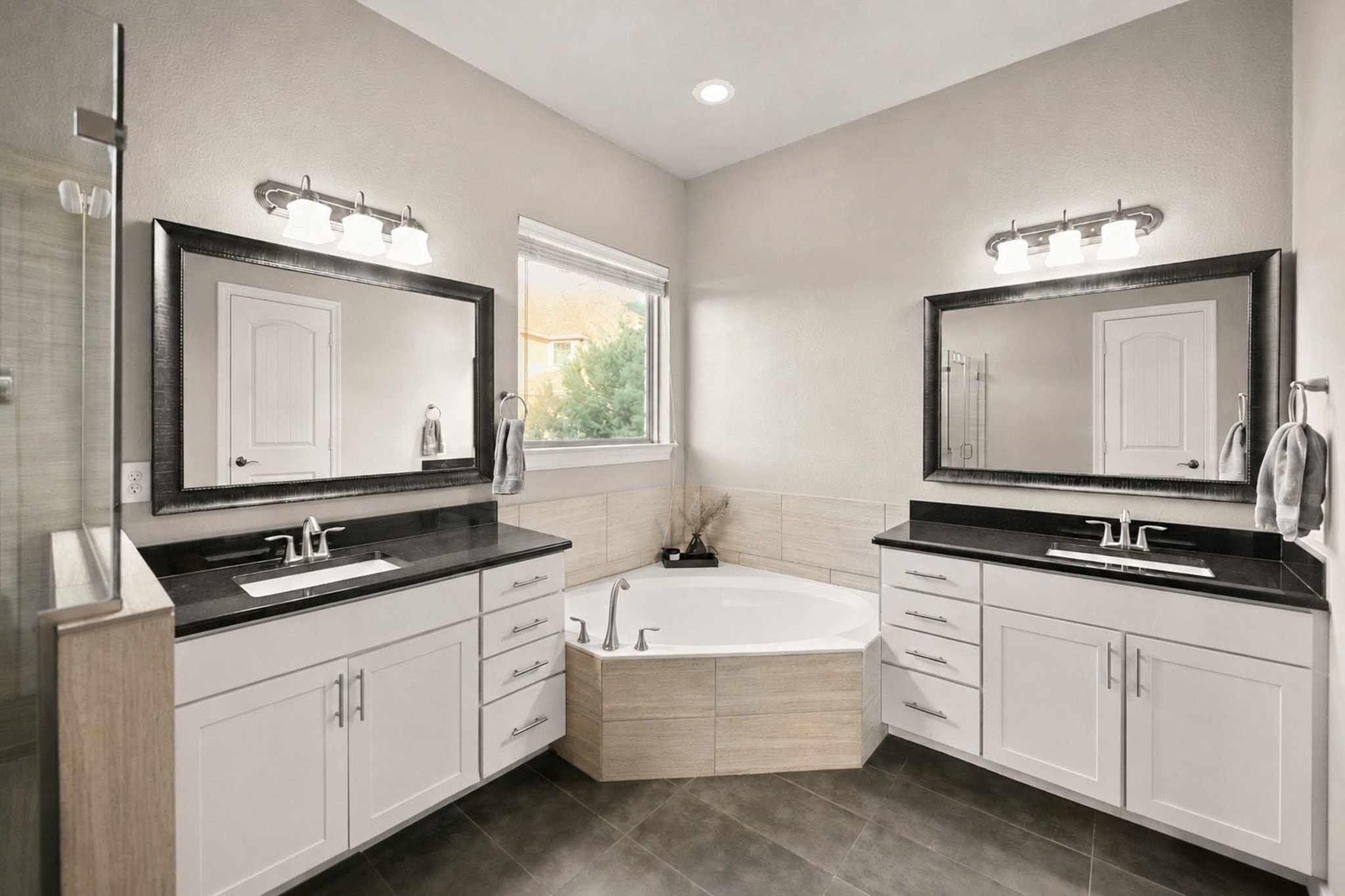 22524 Rock Wren Road Spicewood, TX 78669 - Photo 19 of 40 Dual vanity sinks with black countertops, white shaker cabinetry, and individual rectangular mirrors