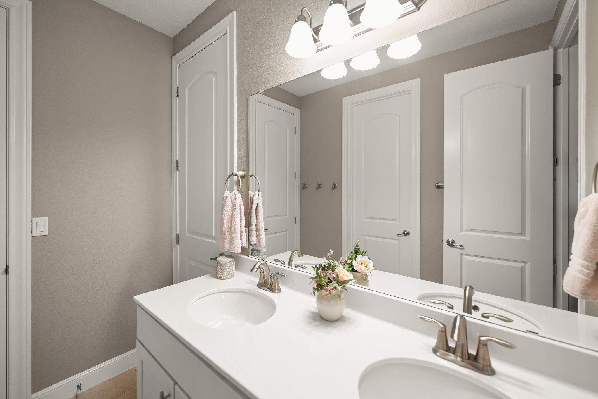 22524 Rock Wren Road Spicewood, TX 78669 - Photo 25 of 40 Dual vanity featuring integrated sinks, brushed nickel fixtures, a full-width mirror, and a four-bulb vanity light fixture