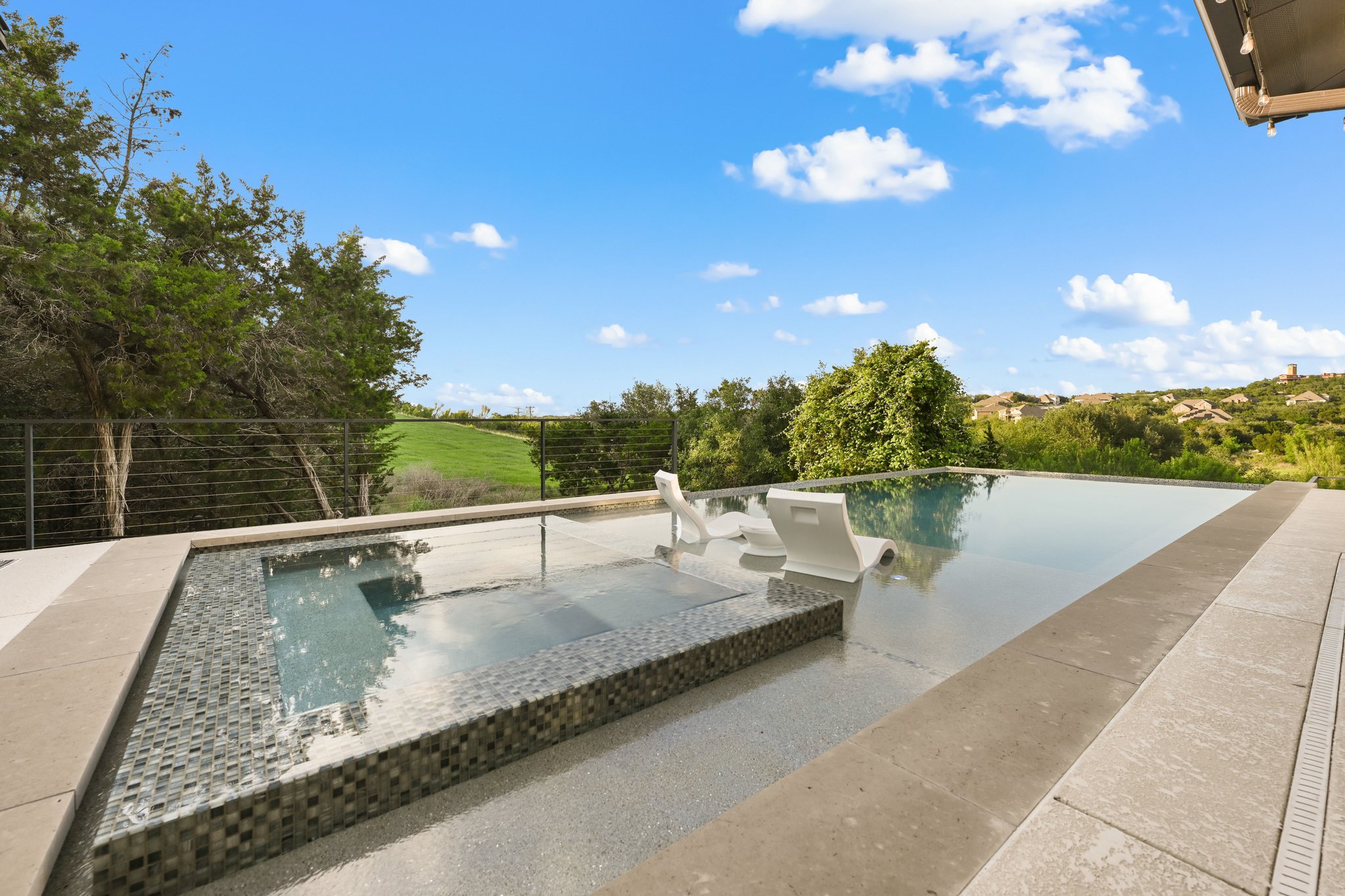 22524 Rock Wren Road Spicewood, TX 78669 - Photo 29 of 40 Infinity-edge pool with an integrated spa featuring mosaic tile accents