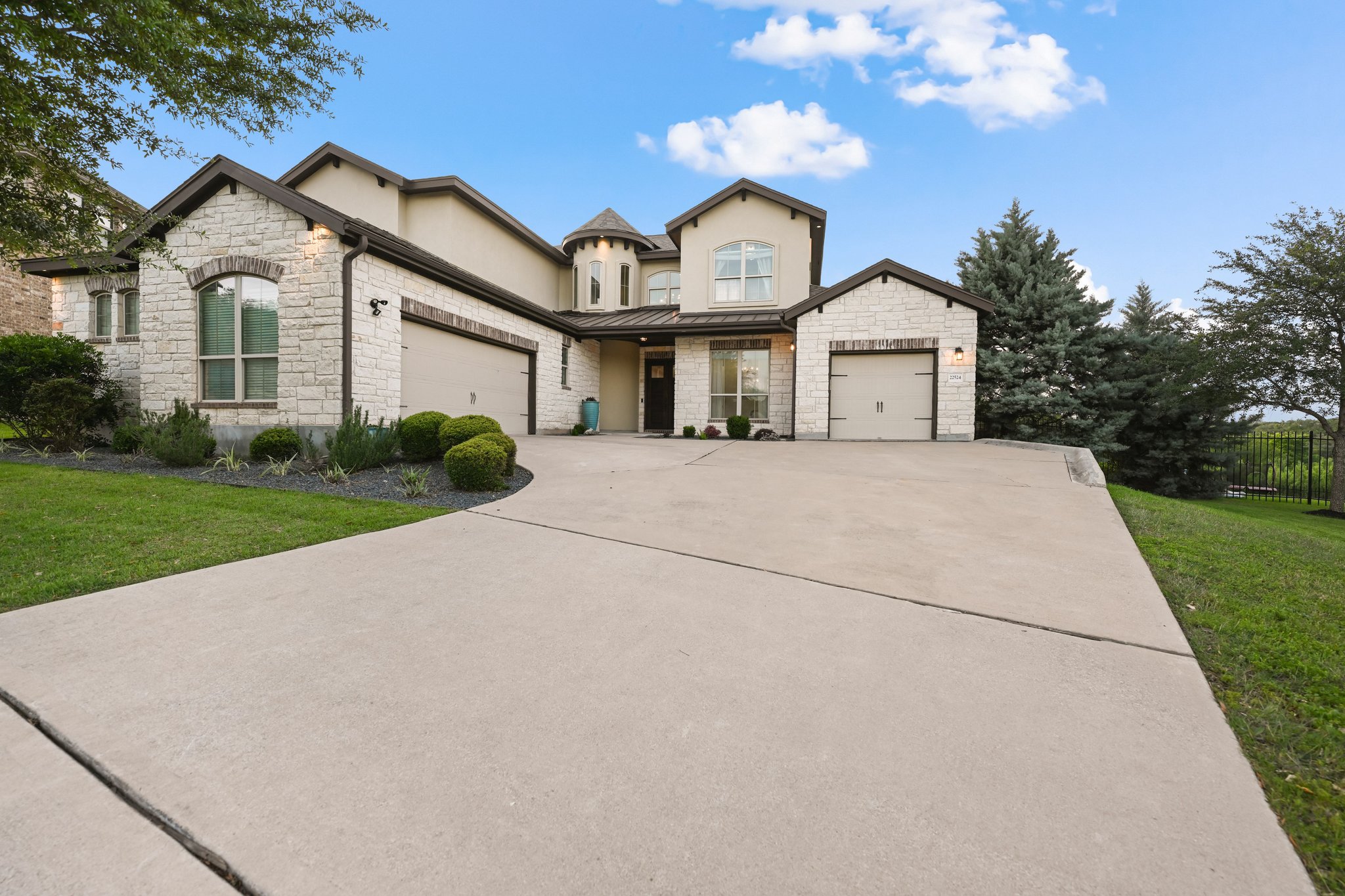 22524 Rock Wren Road Spicewood, TX 78669 - Photo 3 of 40 Stone and stucco exterior with multiple gables