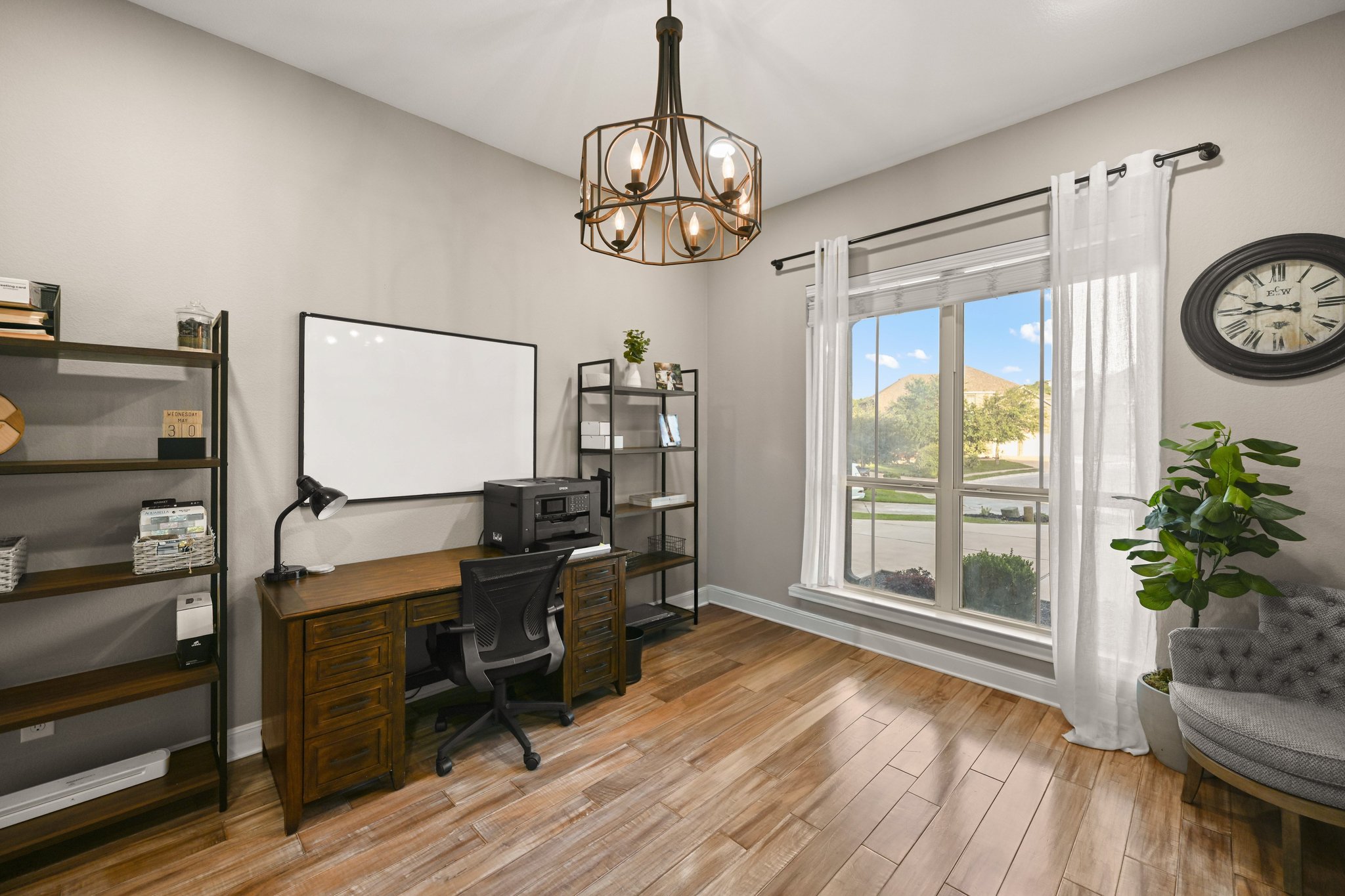 22524 Rock Wren Road Spicewood, TX 78669 - Photo 9 of 40 Spacious room featuring wood-finish flooring, a large window, and a contemporary chandelier