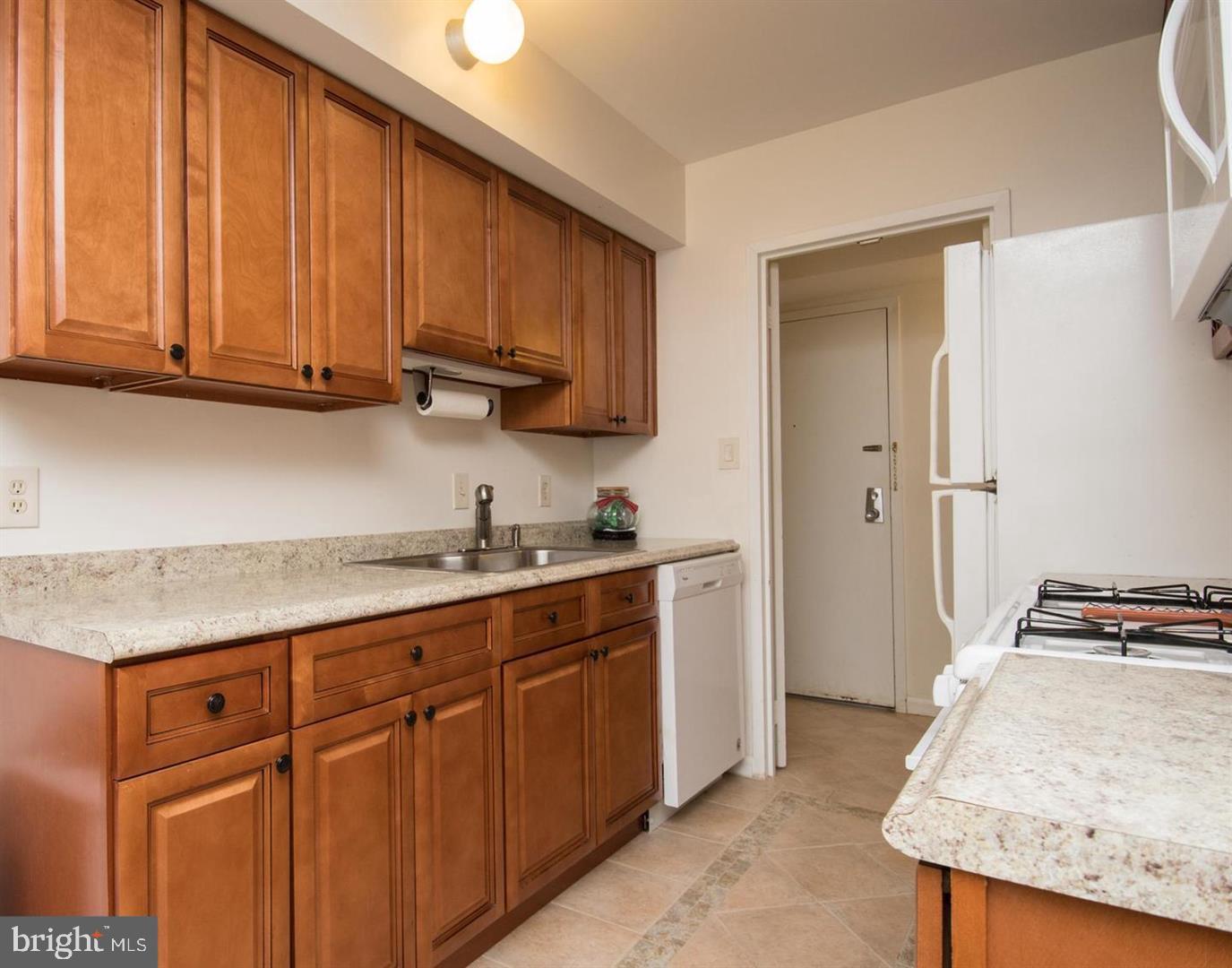 2311 Freetown Court, Unit 19/21C Reston, VA 20191 - Photo 2 of 20 a kitchen with granite countertop wood cabinets and white appliances