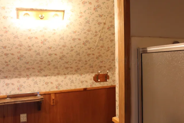 a living room with a large window and wooden floor