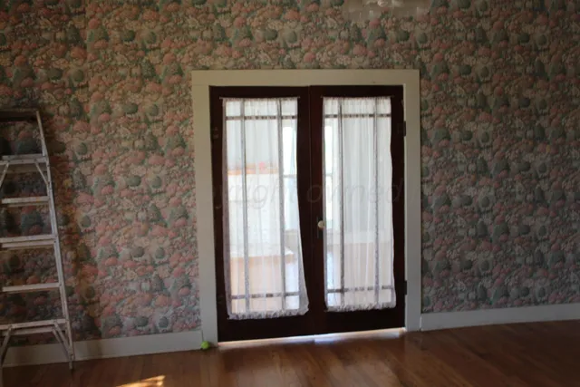 a view of a room with a wooden floor and a ceiling fan