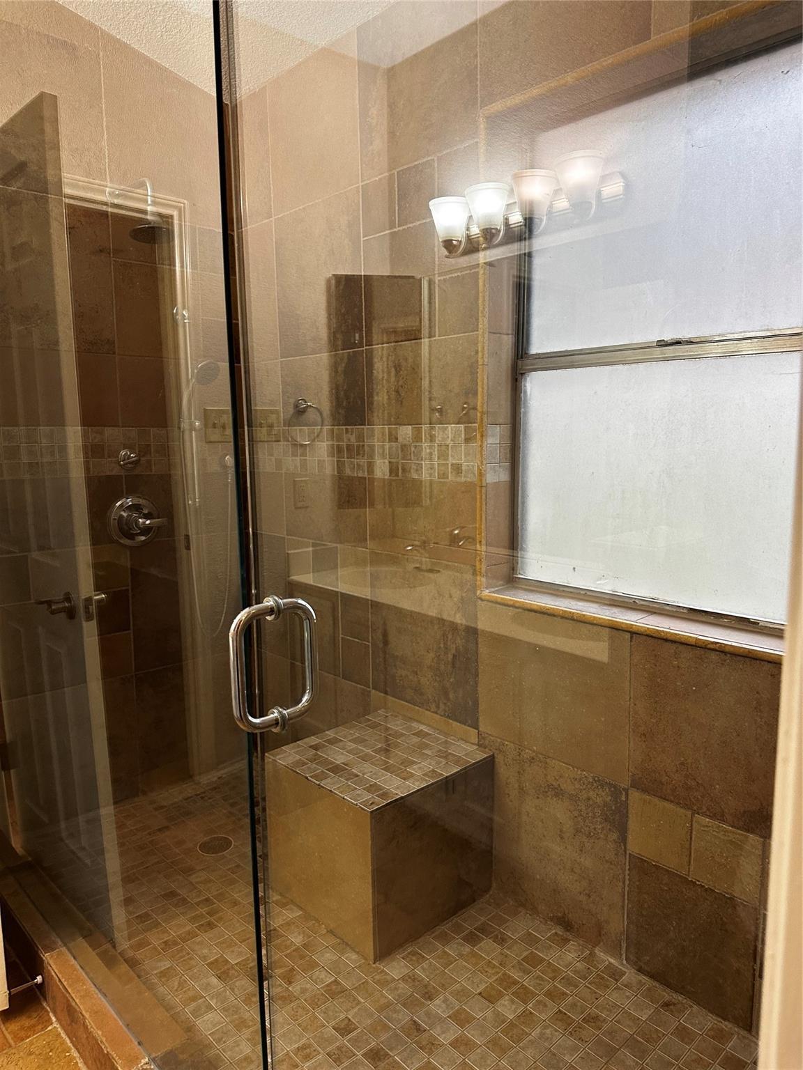 8007 Bounty Trail Austin, TX 78749 - Photo 23 of 32 A spacious, tiled shower features a built-in bench, offering comfort and style.