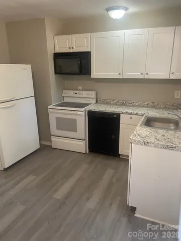 a white kitchen with a stove top oven