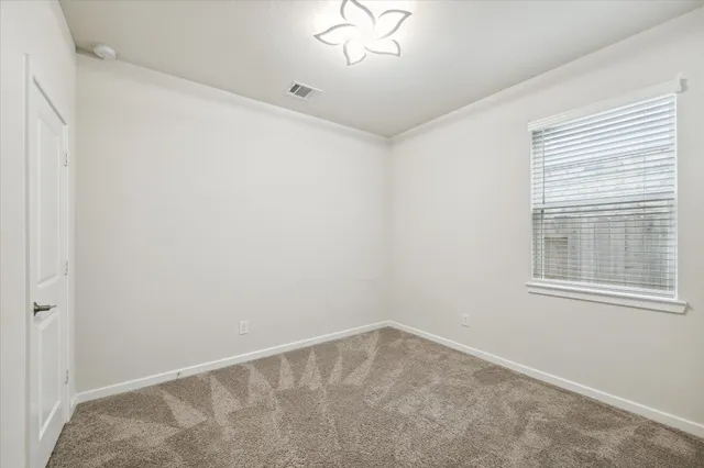 a spacious bedroom with a bed and a chandelier