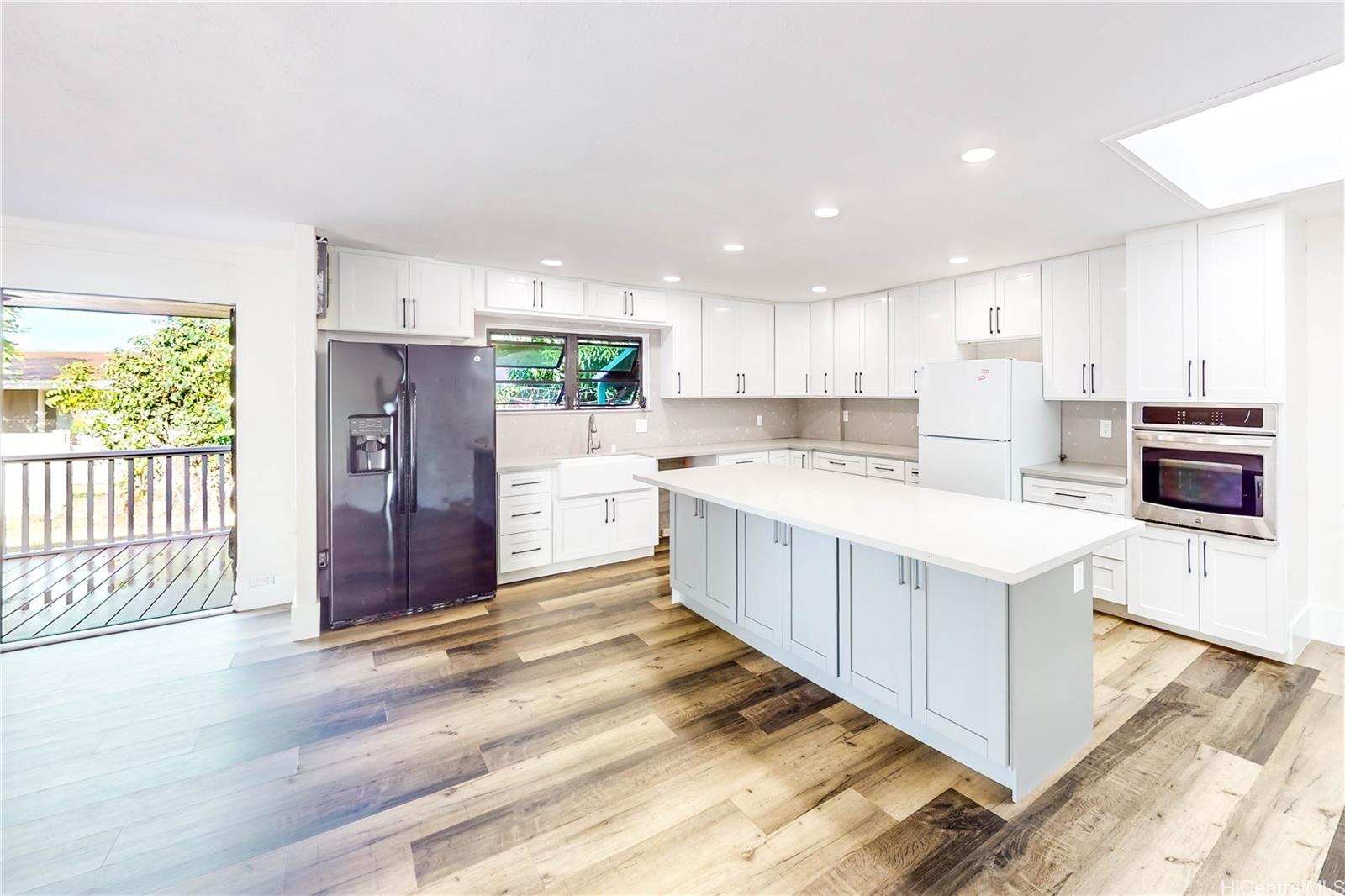 1543 Mahie Place Honolulu, HI 96818 - Photo 3 of 25 a kitchen with stainless steel appliances kitchen island granite countertop a stove top oven a refrigerator a sink and dishwasher with white cabinets