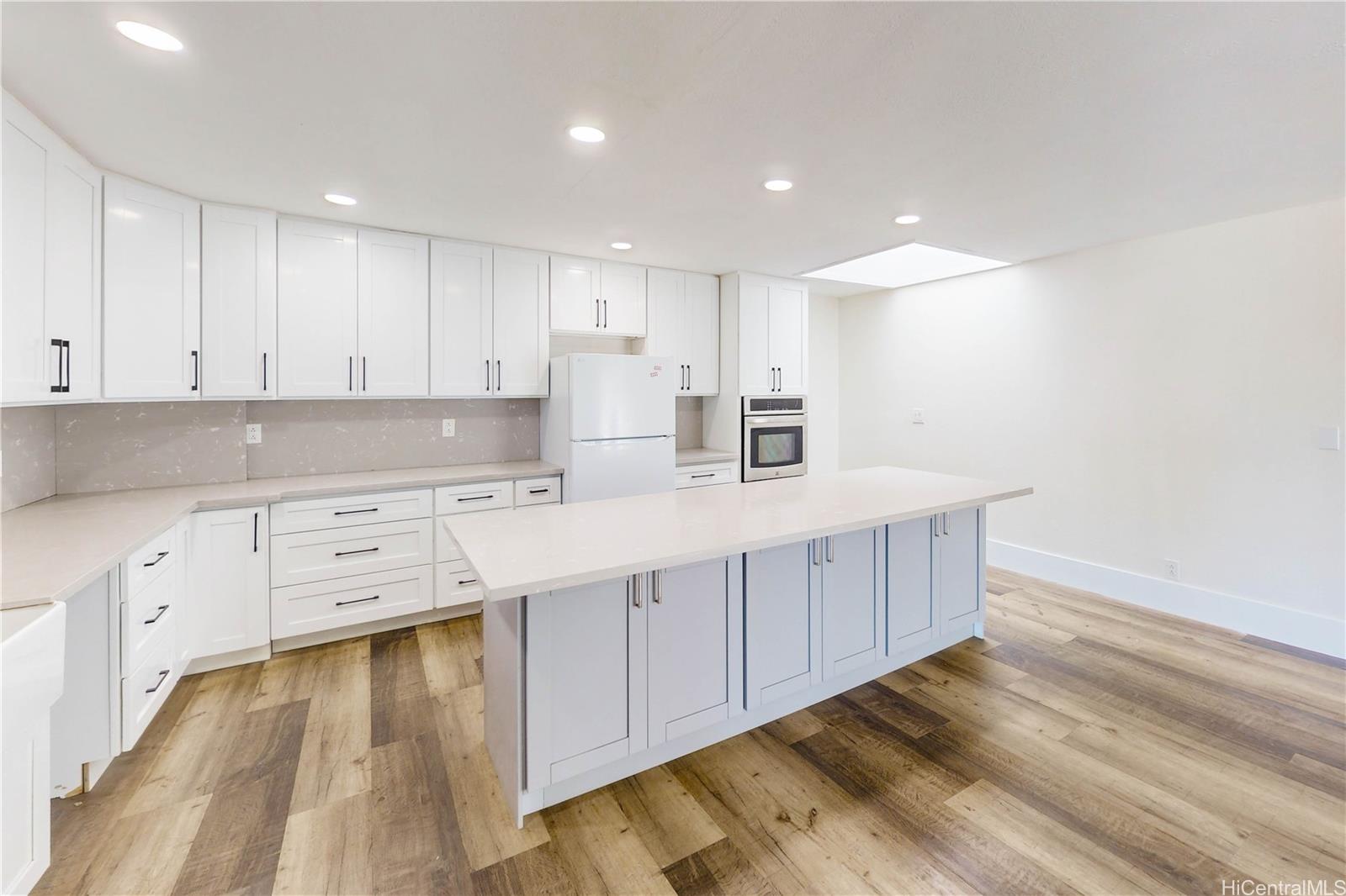 1543 Mahie Place Honolulu, HI 96818 - Photo 4 of 25 a kitchen with stainless steel appliances sink cabinets and wooden floor
