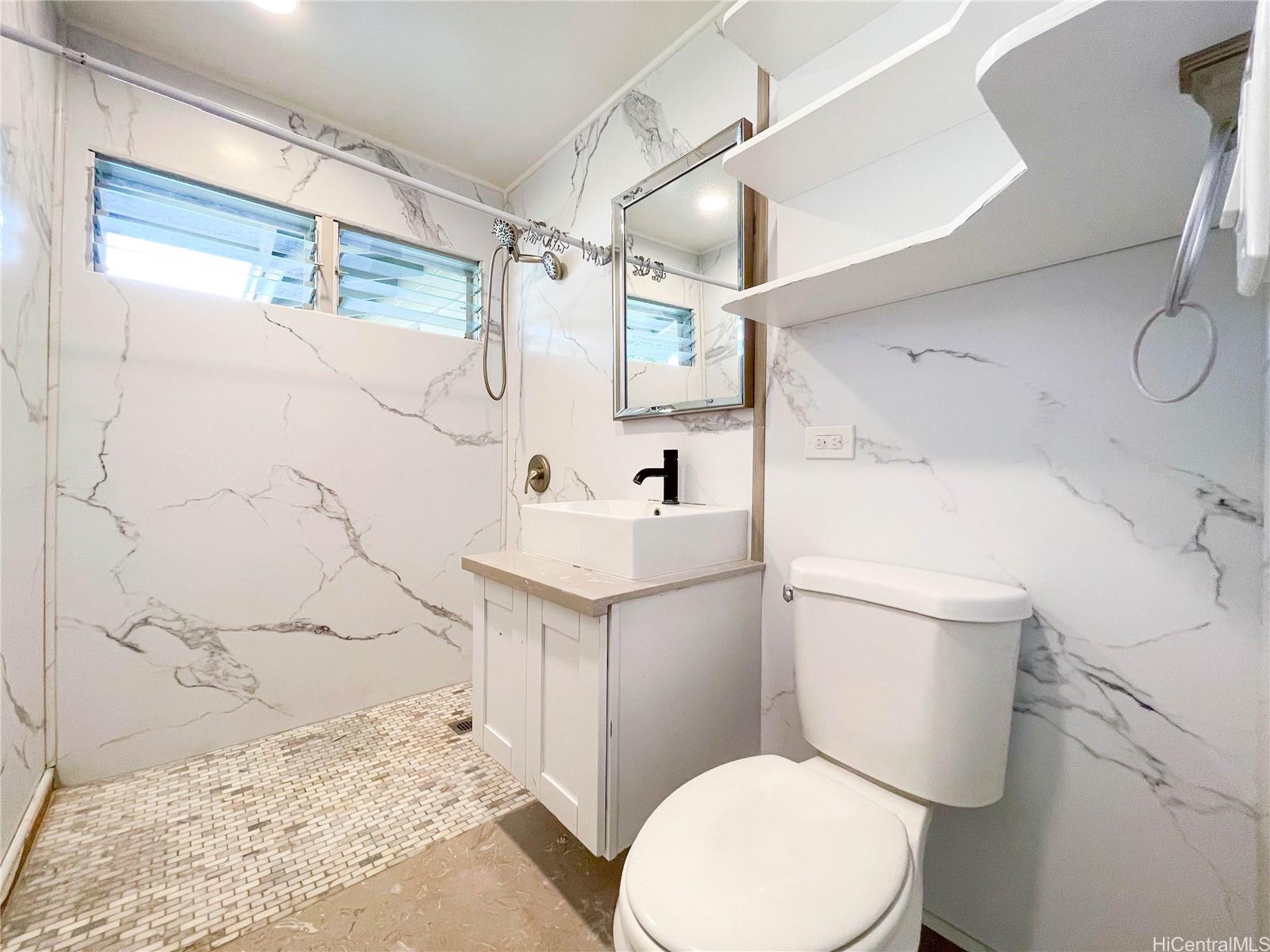 1543 Mahie Place Honolulu, HI 96818 - Photo 8 of 25 a white toilet sitting next to a bathroom sink and a shower