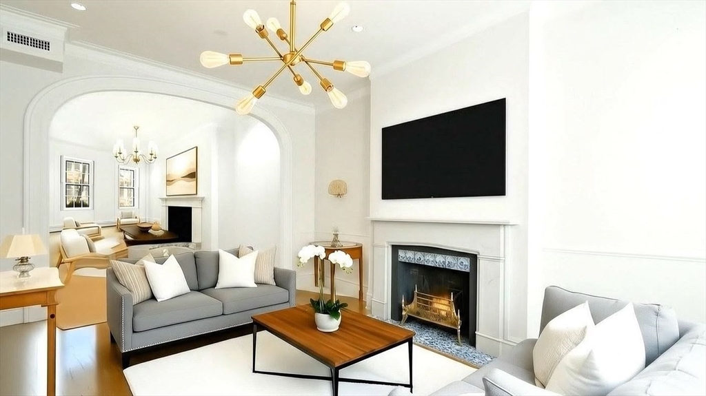 a living room with furniture a flat screen tv and a fireplace