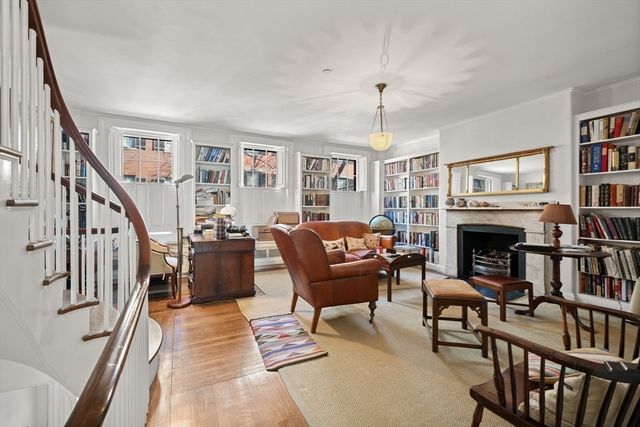a living room with furniture a fireplace and a book shelf
