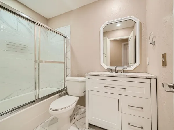 a bathroom with a toilet a sink and shower