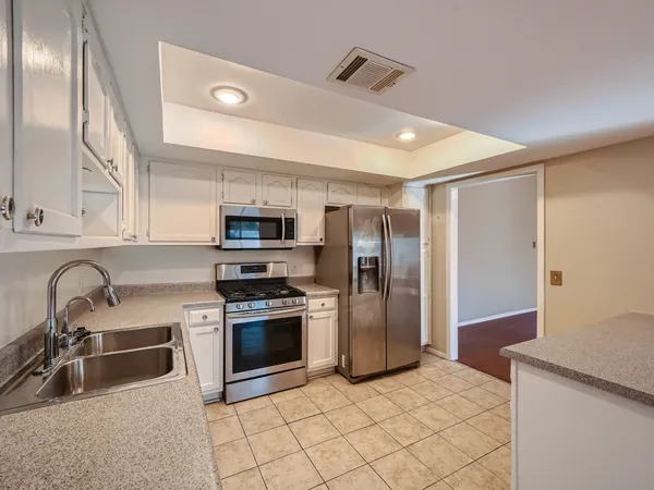 a kitchen with stainless steel appliances granite countertop a refrigerator and a sink