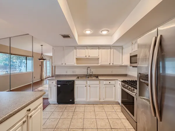 a kitchen with stainless steel appliances granite countertop a stove a sink and a refrigerator