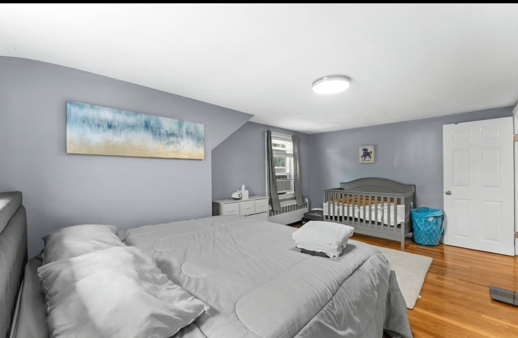 44 Woodlawn Avenue, Unit 2 Everett, MA 02149 - Photo 11 of 18 a bedroom with a bed and a window