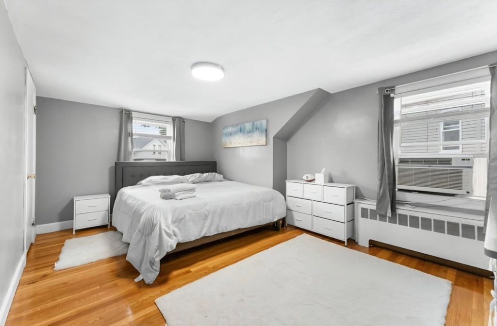 44 Woodlawn Avenue, Unit 2 Everett, MA 02149 - Photo 12 of 18 a bedroom with a bed and wooden floor