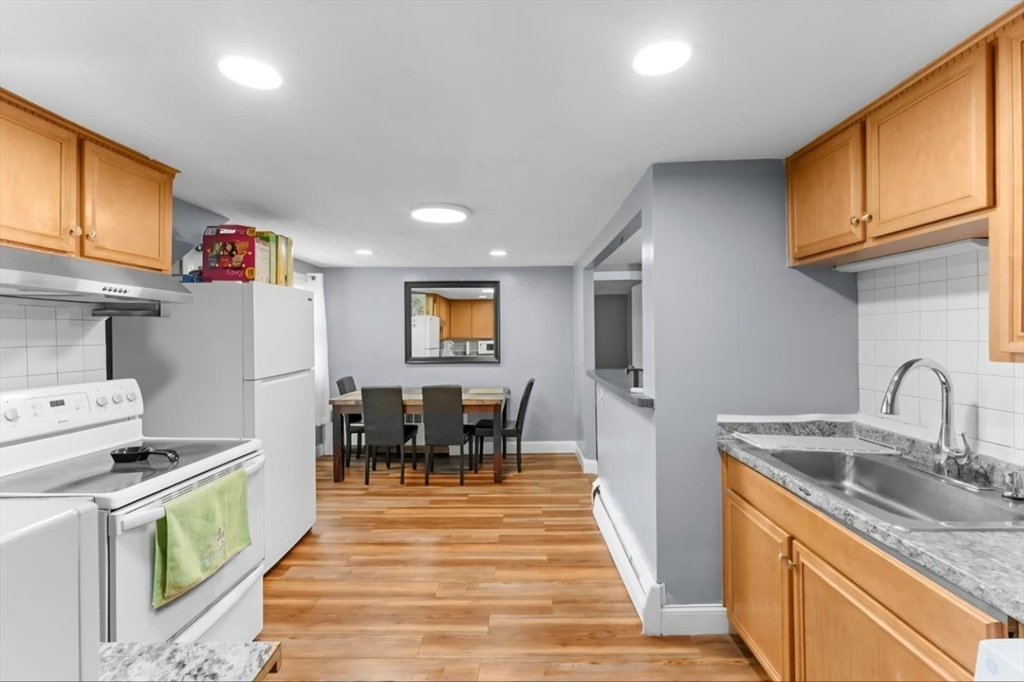 44 Woodlawn Avenue, Unit 2 Everett, MA 02149 - Photo 3 of 18 a kitchen with granite countertop a sink stove and cabinets