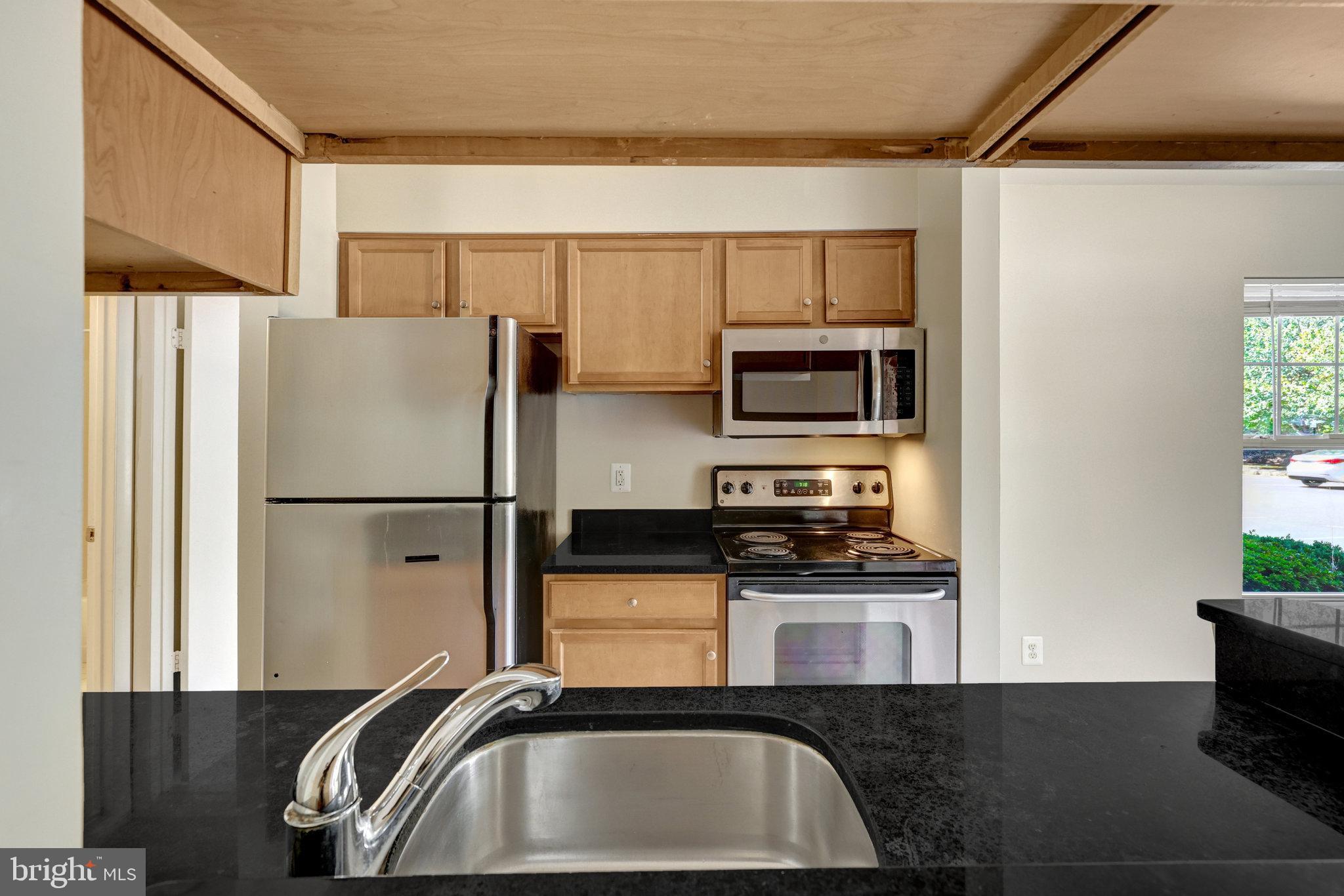 1791 Jonathan Way, Unit 1791B Reston, VA 20190 - Photo 1 of 27 a kitchen with granite countertop a refrigerator and a sink