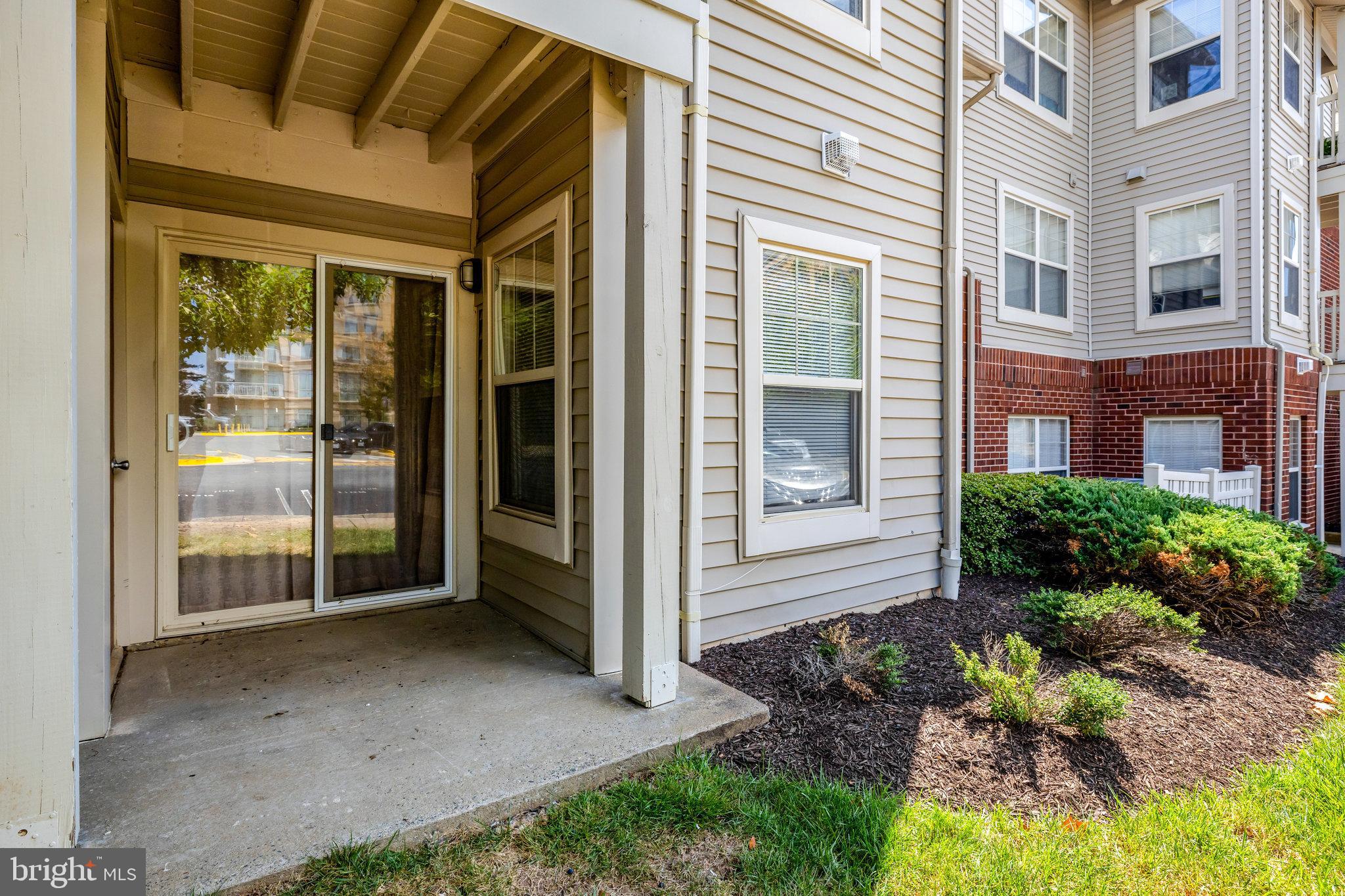 1791 Jonathan Way, Unit 1791B Reston, VA 20190 - Photo 16 of 27 a view of yellow house with a floor to ceiling windows and a yard