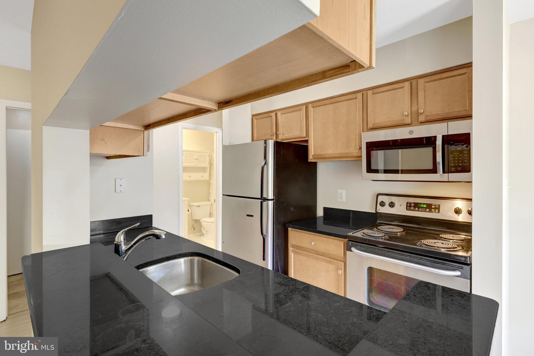 1791 Jonathan Way, Unit 1791B Reston, VA 20190 - Photo 2 of 27 a kitchen with granite countertop a refrigerator stove and sink