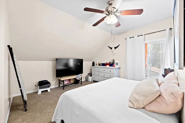 a bedroom with a bed and a flat tv screen on the dresser