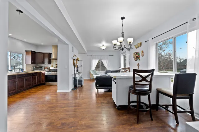 a view of a dining room with furniture a chandelier and wooden floor