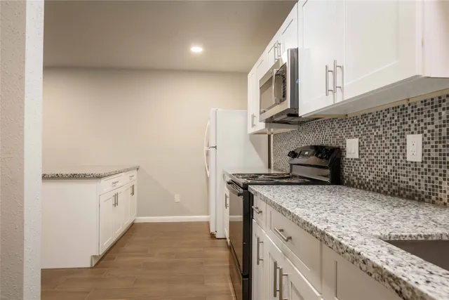 a kitchen with stainless steel appliances granite countertop a sink and a stove