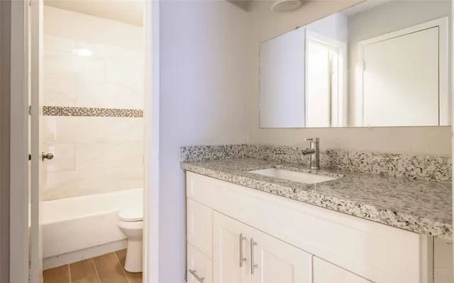 a bathroom with a granite countertop sink and a mirror