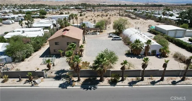 an aerial view of a house with a yard patio and mountain view in back