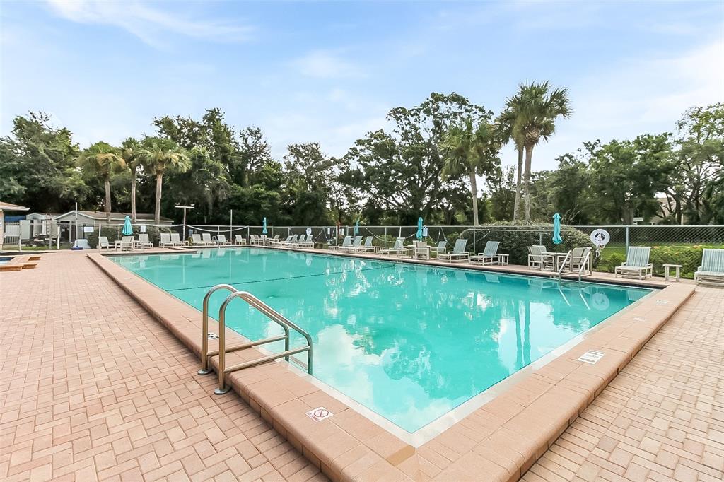 6338 Spring Flower Drive, Unit 21 New Port Richey, FL 34653 - Photo 13 of 18 a view of a swimming pool with a patio and a yard