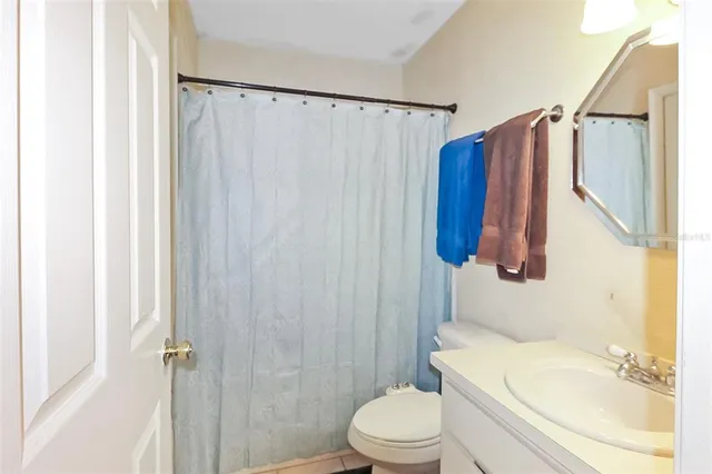 a bathroom with a sink a toilet and shower curtain
