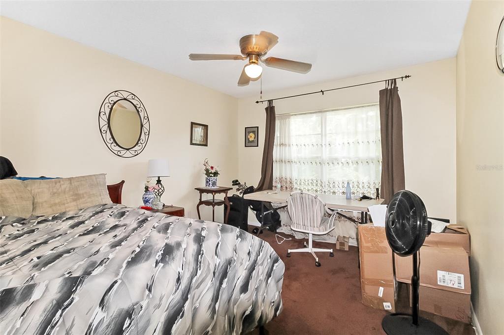 6338 Spring Flower Drive, Unit 21 New Port Richey, FL 34653 - Photo 6 of 18 a bedroom with a bed and a chandelier