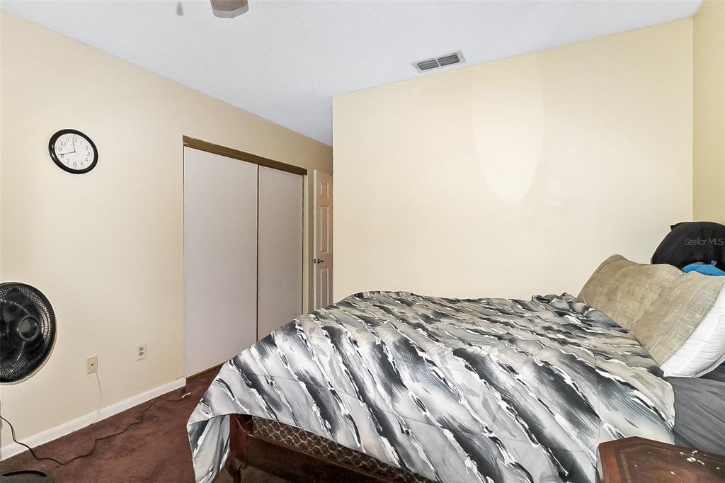 6338 Spring Flower Drive, Unit 21 New Port Richey, FL 34653 - Photo 7 of 18 a bedroom with a bed and a table in it