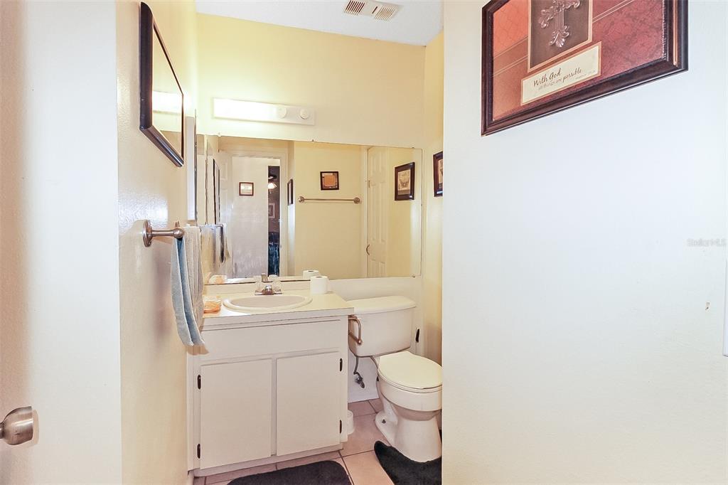 6338 Spring Flower Drive, Unit 21 New Port Richey, FL 34653 - Photo 9 of 18 a bathroom with a toilet sink and mirror