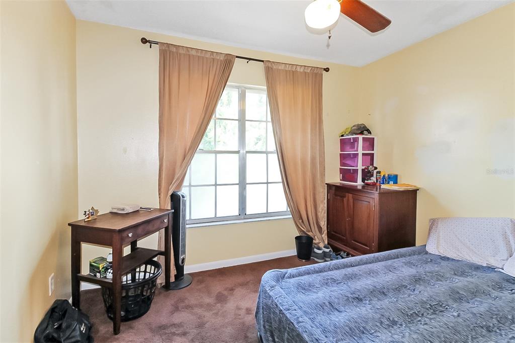 6338 Spring Flower Drive, Unit 21 New Port Richey, FL 34653 - Photo 10 of 18 a bedroom with furniture and a window