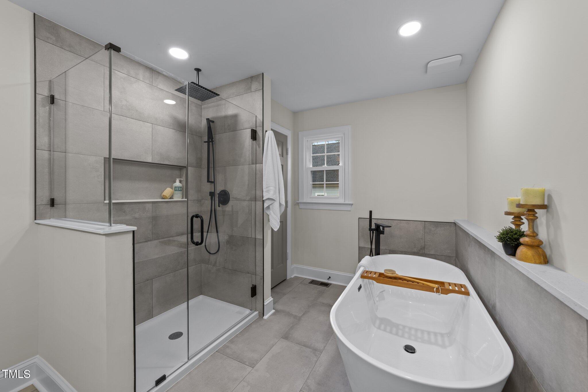 2108 Rangecrest Road Raleigh, NC 27612 - Photo 17 of 38 a bathroom with a tub shower sink and mirror