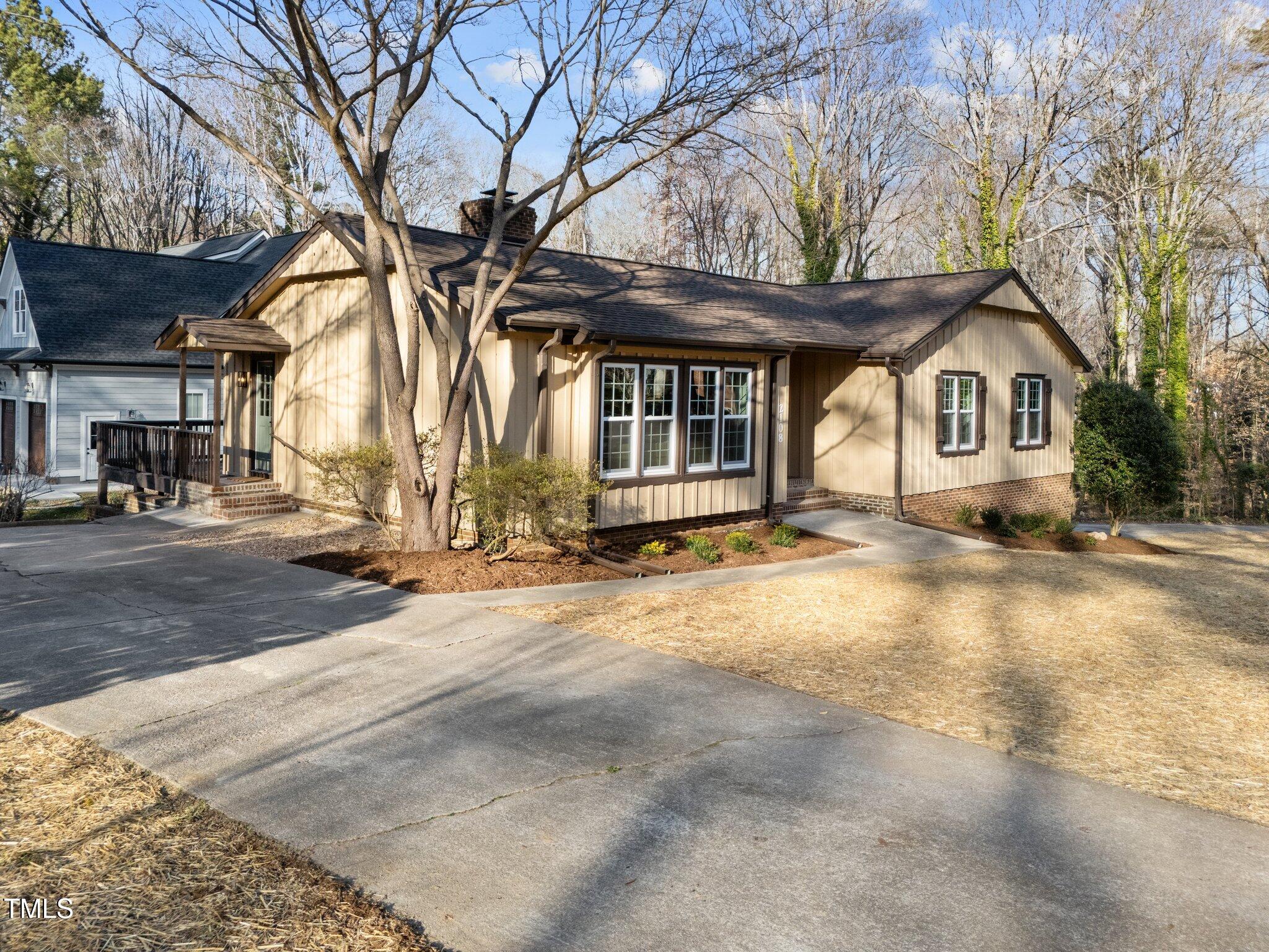 2108 Rangecrest Road Raleigh, NC 27612 - Photo 2 of 38 a view of a house with a large tree and wooden fence