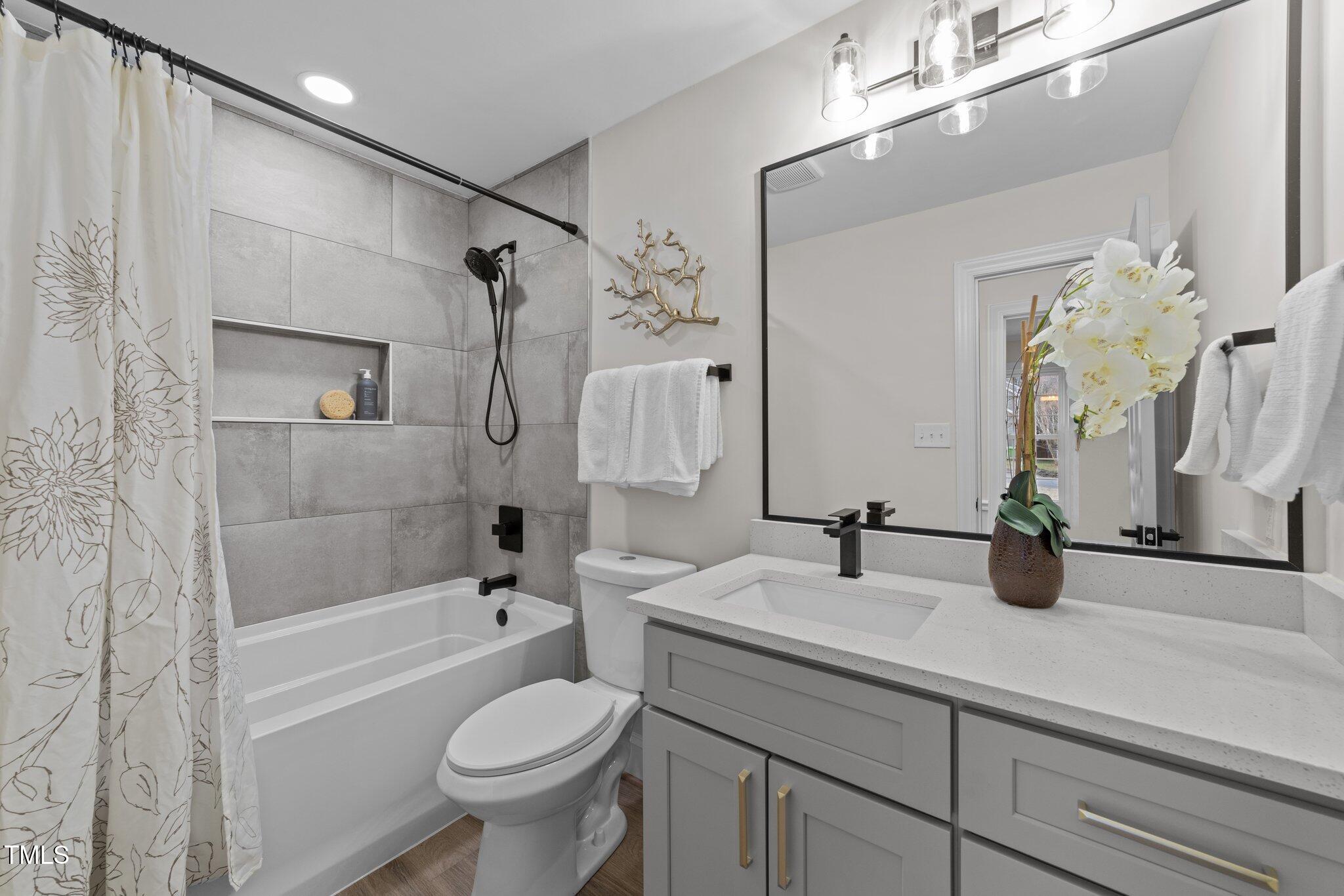 2108 Rangecrest Road Raleigh, NC 27612 - Photo 22 of 38 a bathroom with a sink a toilet and shower